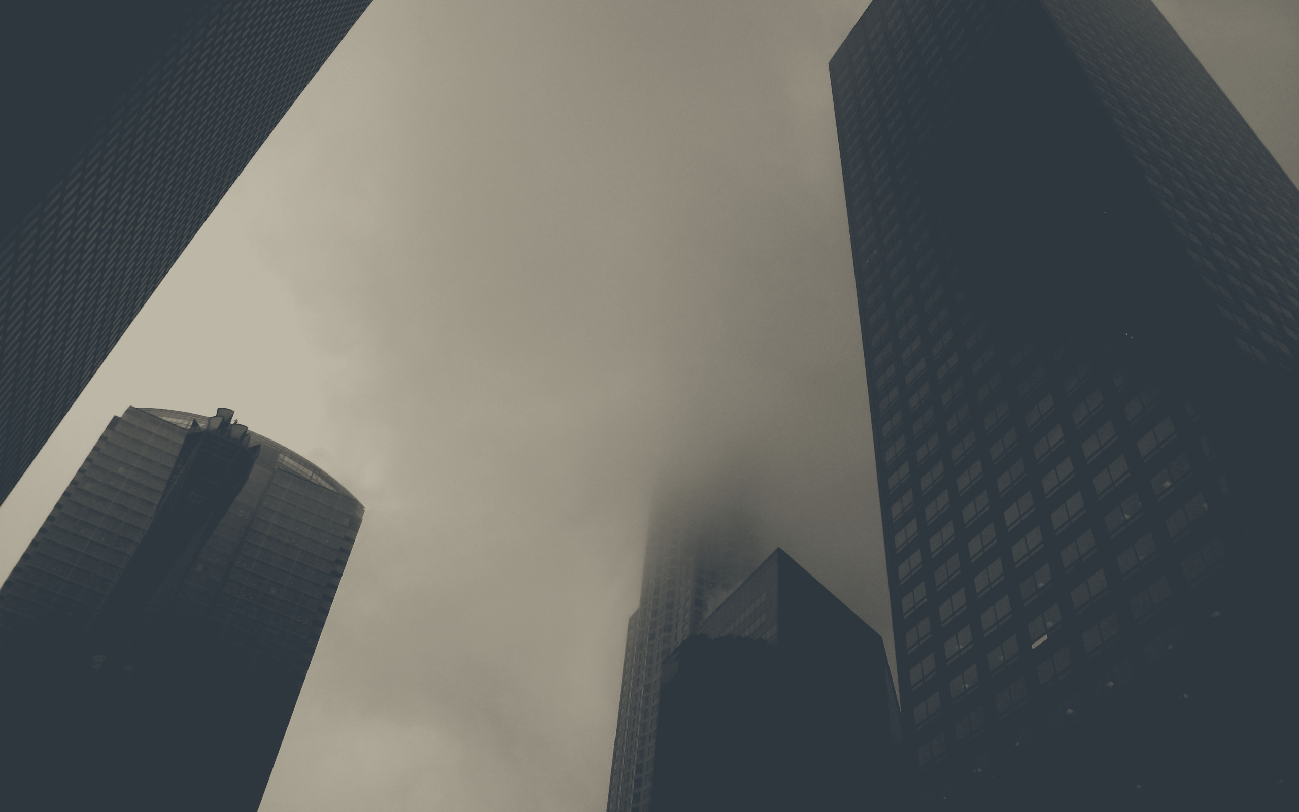 a_group_of_tall_buildings_with_clouds_in_the_sky