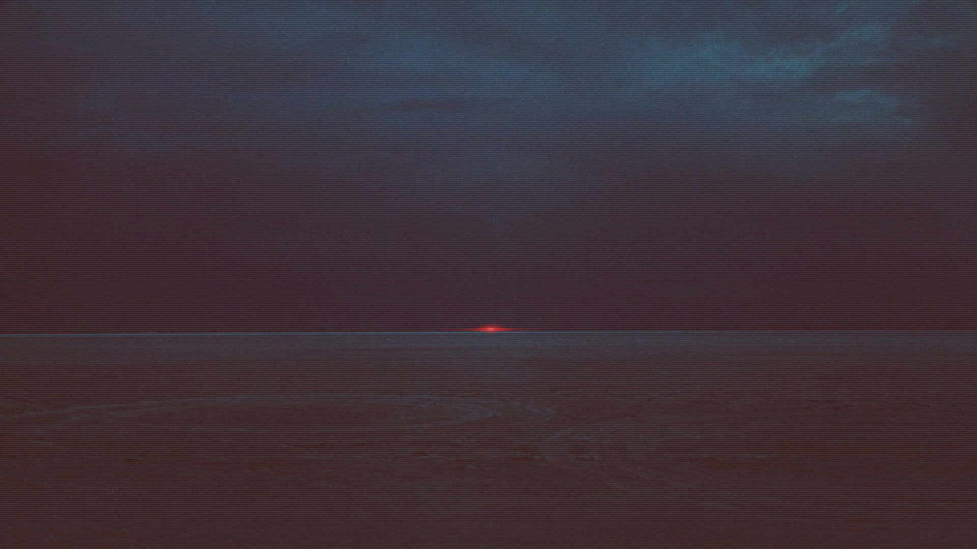 a_sunset_over_a_body_of_water_with_Marfa_lights_in_the_background